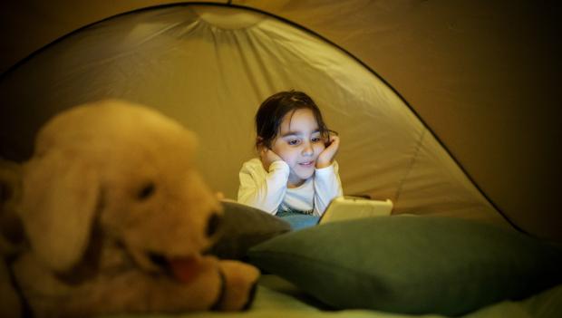 Young girl in a tent with her favorite toy